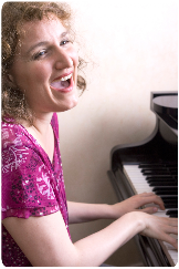 Gesangslehrerin Micada singend am Klavier